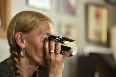 Portrait of woman holding camera at home