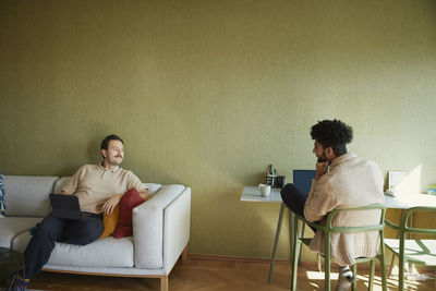 Homosexual couple relaxing in living room