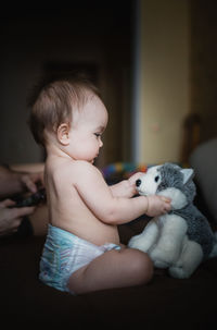 Cute baby boy with toy at home