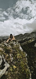 Mid distance view of man sitting on mountain