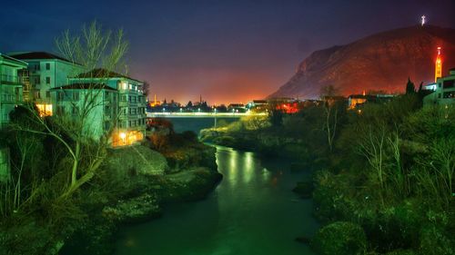 Illuminated city against sky at night