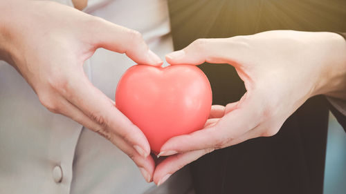 Close-up of hand holding red balloon