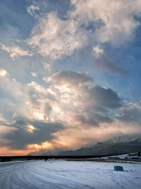 Scenic view of snow covered mountains against sky during sunset