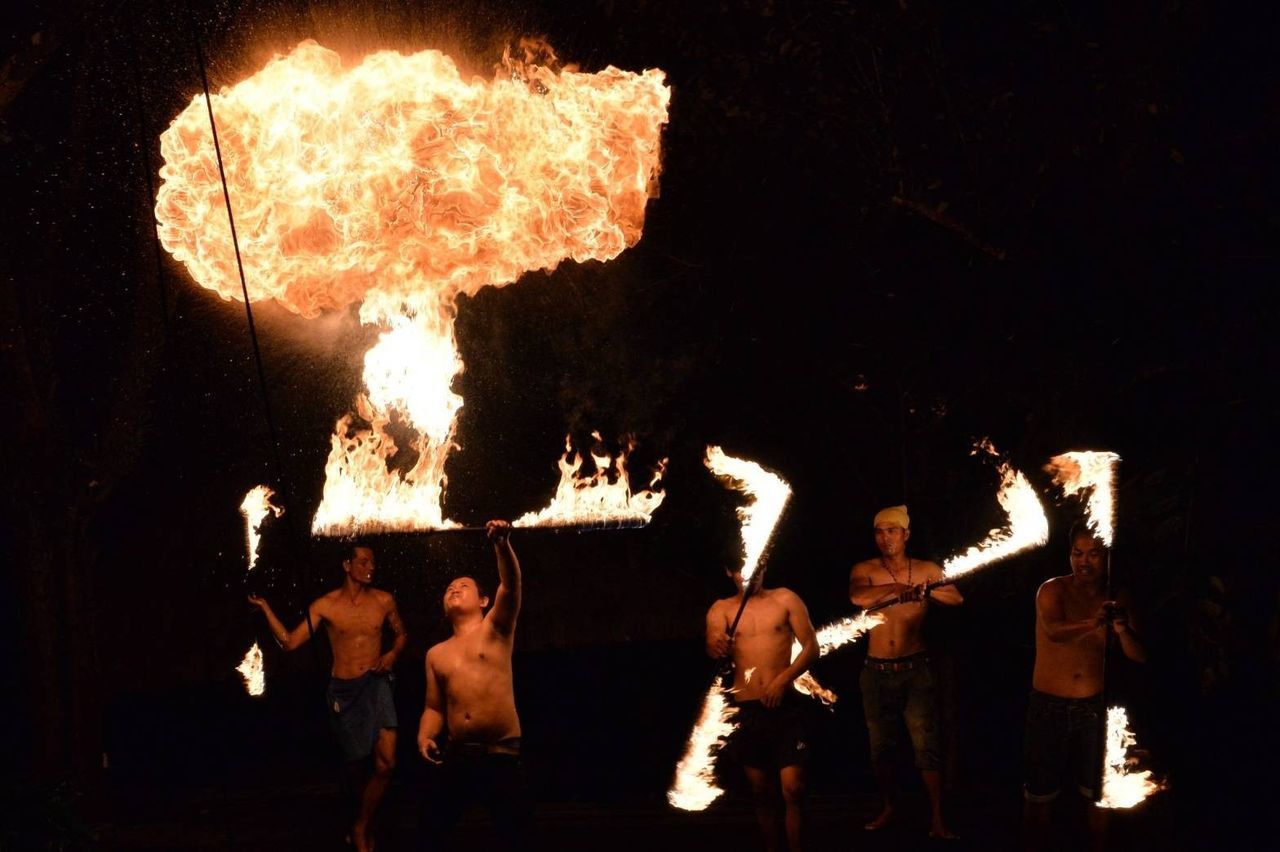 group of people, night, performance, arts culture and entertainment, men, burning, motion, flame, real people, crowd, event, skill, fire - natural phenomenon, fire, heat - temperature, shirtless, large group of people, standing, music, performing arts event, rock music