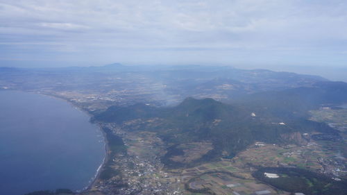 Aerial view of sea and mountains against sky