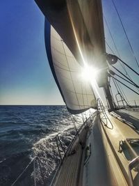 Sailboat sailing on sea against clear sky