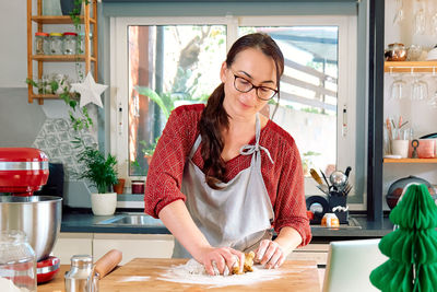 Woman kneading dough with her hands for christmas gingerbread cookies, baking homemade pastries