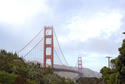 Suspension bridge against cloudy sky