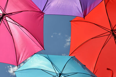 Low angle view of multi colored umbrellas against sky