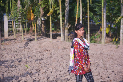 Full length of smiling woman standing on land