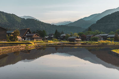 Scenic view of houses and mountains against sky