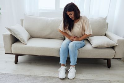 Young woman sitting on sofa at home