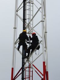 Low angle view of man working against sky