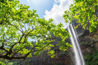 Low angle view of waterfall on mountain sky