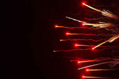 Low angle view of illuminated fireworks against sky at night