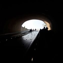 Silhouette people standing in tunnel