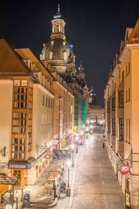 Street amidst buildings in city at night