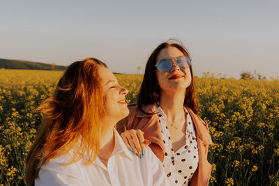 Young woman wearing sunglasses while standing against sky