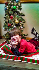 Portrait of smiling boy with christmas tree