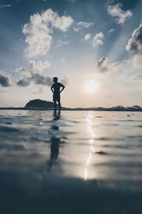 Rear view of man in sea against sky