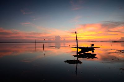 Silhouette of sailboat in sea against sky during sunset