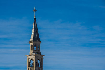 Bell tower with tin roof and cloudy sky in the background in camporovere, asiago, vicenza, italy