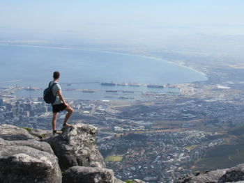 Side view of man on cliff over city