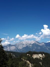 Scenic view of snowcapped mountains against blue sky