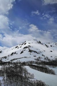 Scenic view of snow covered mountains against sky