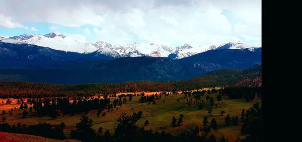 Scenic view of snowcapped mountains against cloudy sky