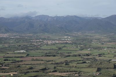 Aerial view of agricultural field and mountains against sky