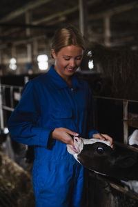 Woman feeding cow in barn