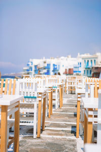 Chairs and tables at beach against clear sky