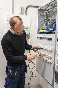 Repairman repairing meter box while working in industry