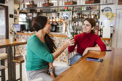 Smiling young woman sitting at cafe