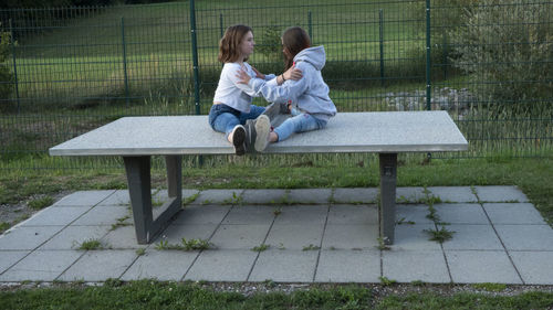 Rear view of couple sitting on bench in park