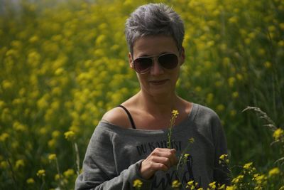 Portrait of man wearing sunglasses standing on field