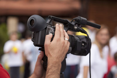 Cropped hands of photographer holding camera