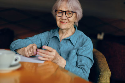 Portrait of smiling senior businesswoman in cafe
