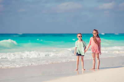 Woman standing on beach against sky