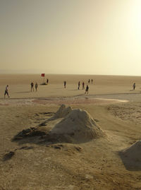 Tourist visiting tunisia desert against sky during sunset