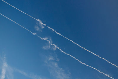 Low angle view of vapor trail against blue sky