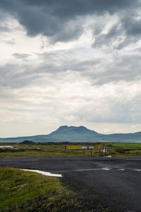 Scenic view of road by mountains against sky