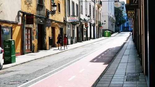 People walking on street amidst buildings in city