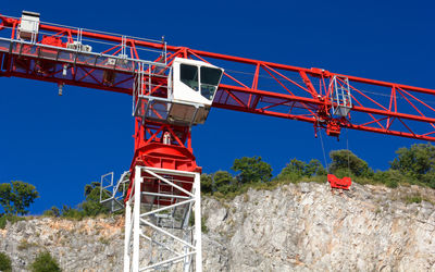 Low angle view of crane against clear blue sky