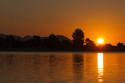 Scenic view of lake against orange sky