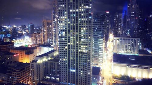 Aerial view of illuminated cityscape against sky at night