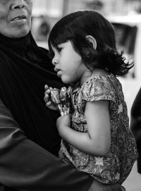 Mother carrying girl with lollipops