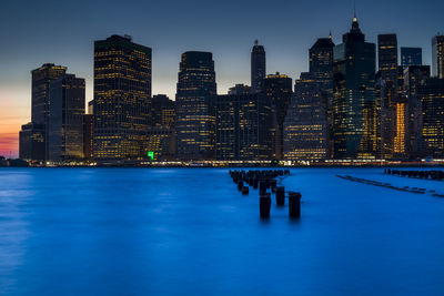 City at waterfront against blue sky