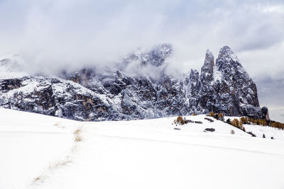 Scenic view of snowcapped mountains against cloudy sky